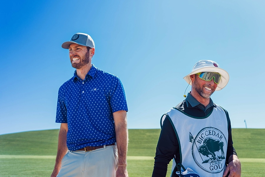caddie and golfer smiling at big cedar nature golf