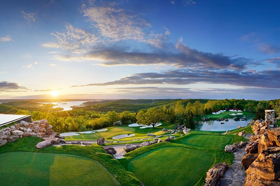 the greens of a golf course cascade down the hills of the ozark mountains