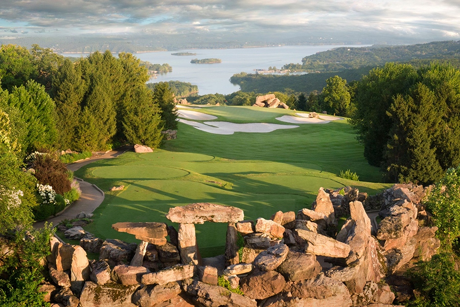 large rocks surround a putting green. beyond the golf course is table rock lake with several islands in the middle