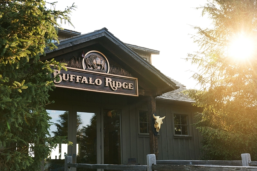 buffalo ridge clubhouse with entry doors glass reflecting nearby forest