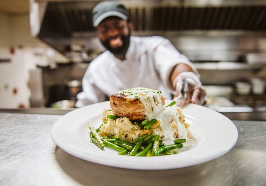 Chef serving up a dish at Devil's pool restaurant at Big Cedar