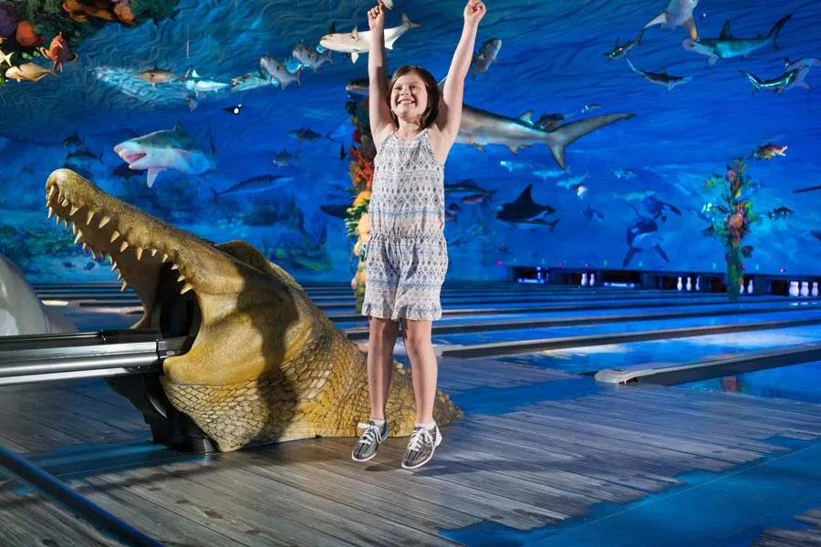 Little girl cheering at Fun Mountain underwater-themed bowling alley at Big Cedar