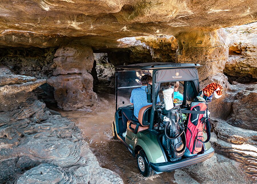 golf cart riding through a cave at cliffhangers golf course