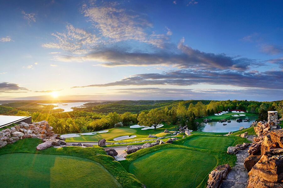 the greens of a golf course cascade down the hills of the ozark mountains
