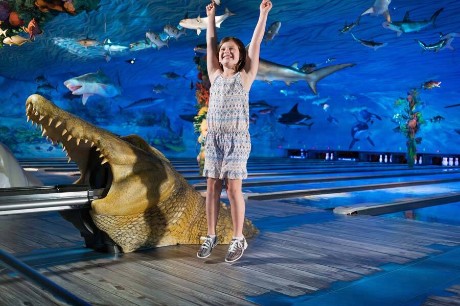 Little girl cheering at Fun Mountain underwater-themed bowling alley at Big Cedar