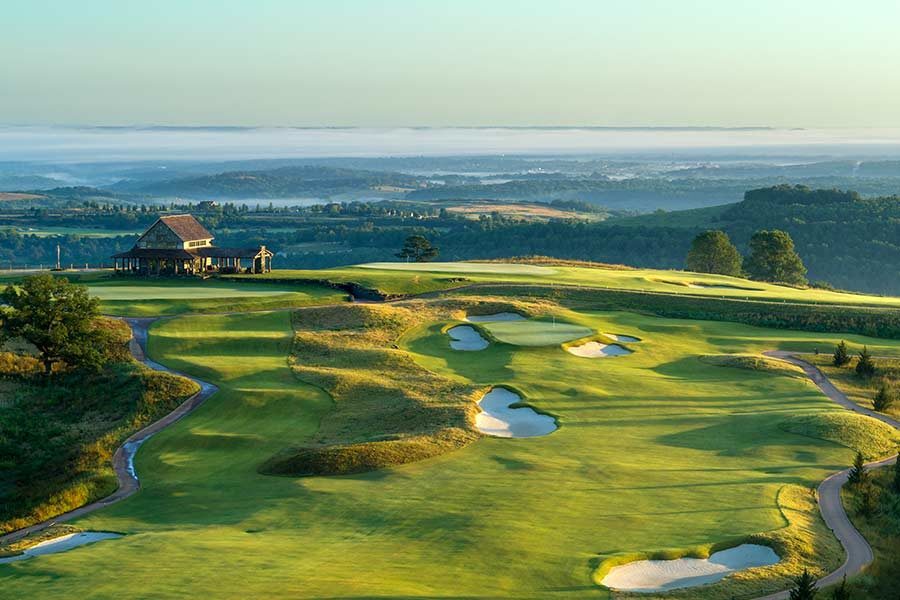 Aerial view of hole number 3 at Ozarks National. Haze covers the lake below in the distance.
