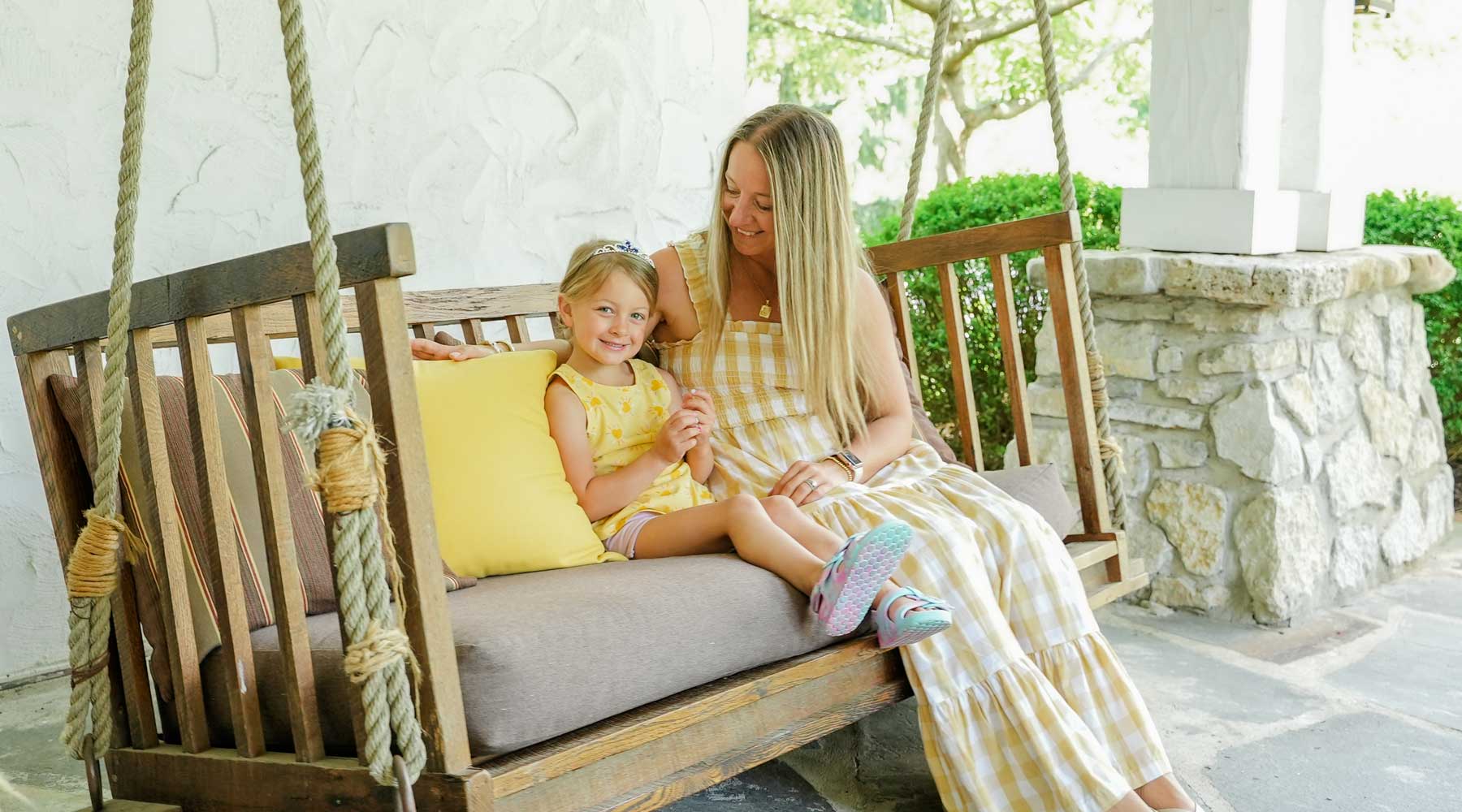 Mother and daughter enjoying the swinging chairs outside Cedar Creek spa