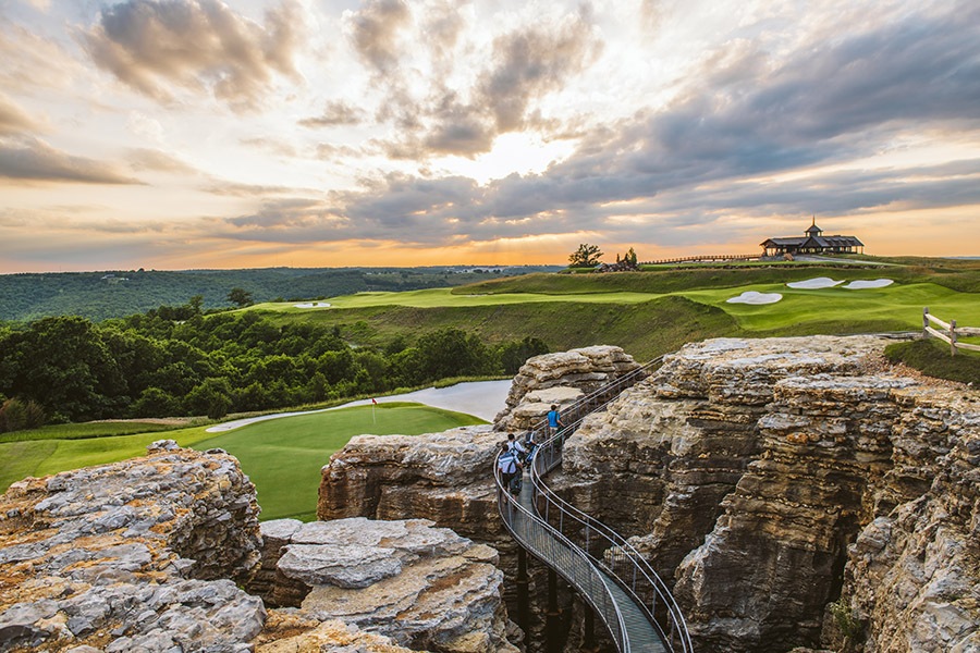 a winding walking bridge curves through the mountainous region of mountain top golf course