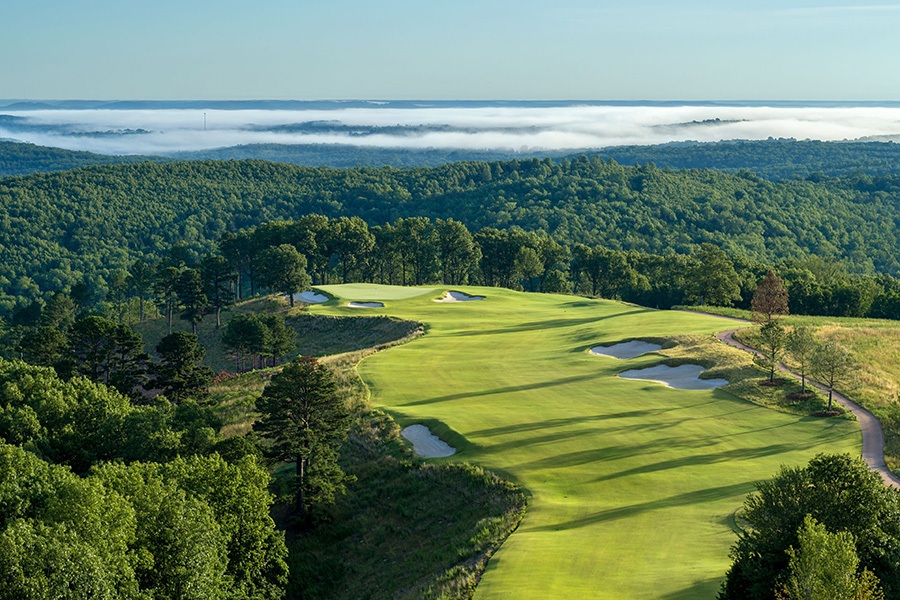 trees cast long shadows over a finely cut fairway
