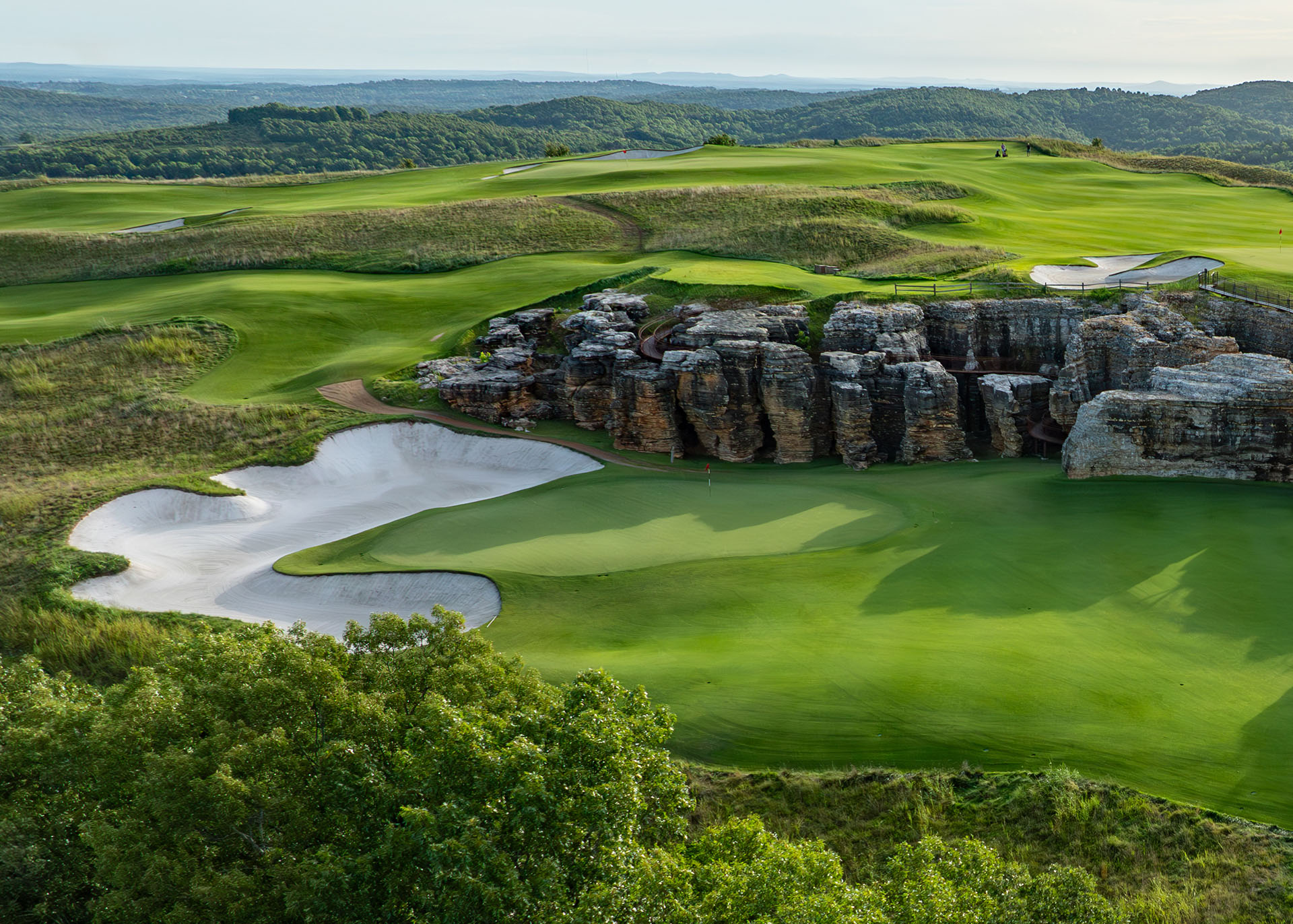 a fully green golf course with a sand bunker