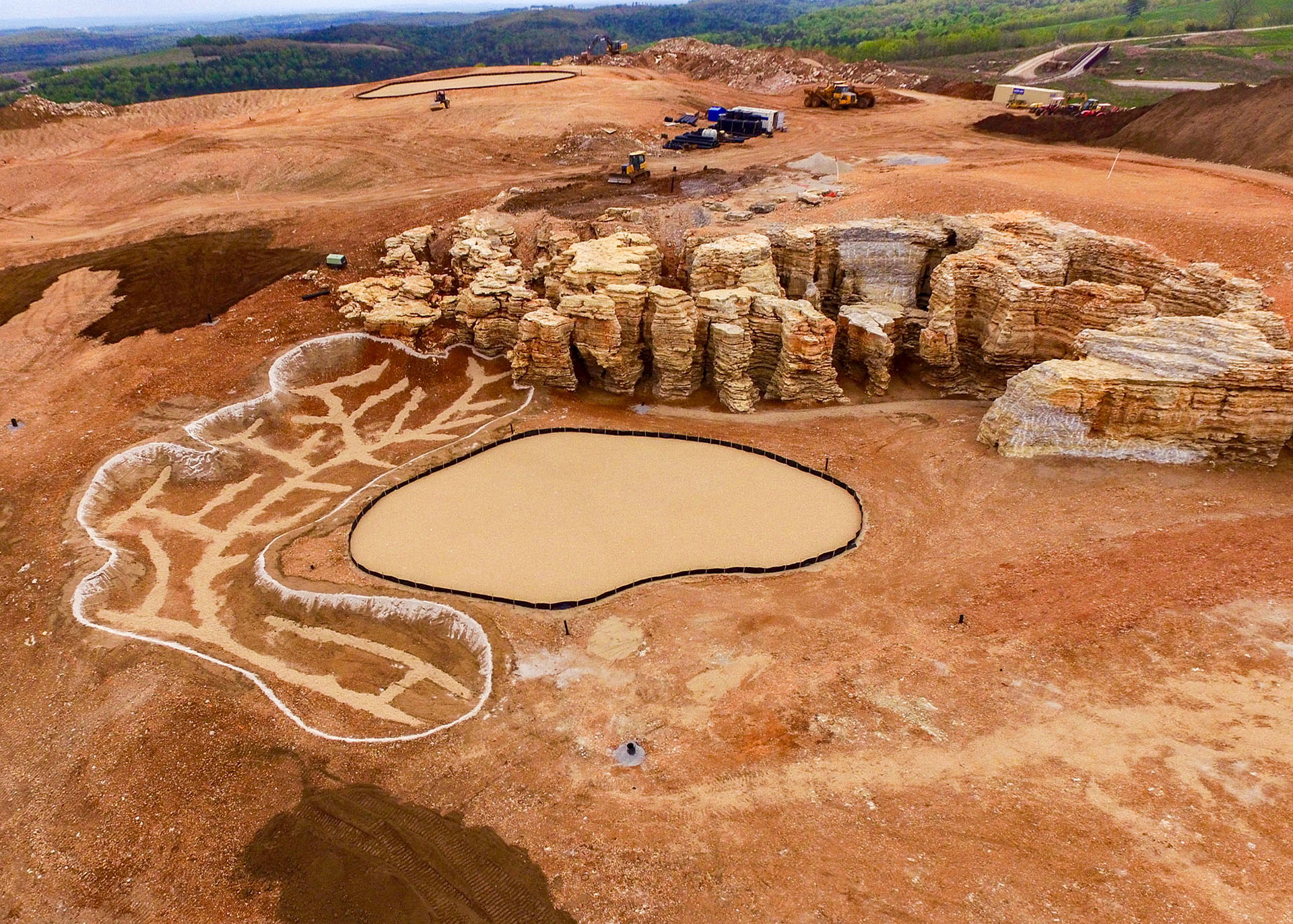 red dirt with the outlines of sand bunkers and putting greens