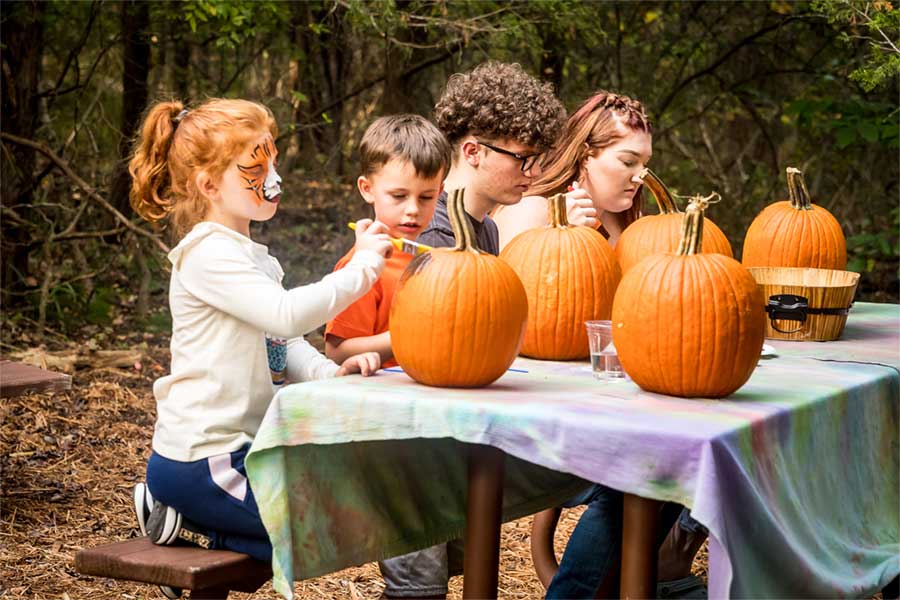 Kids decorating pumpkins at Cedar Fest