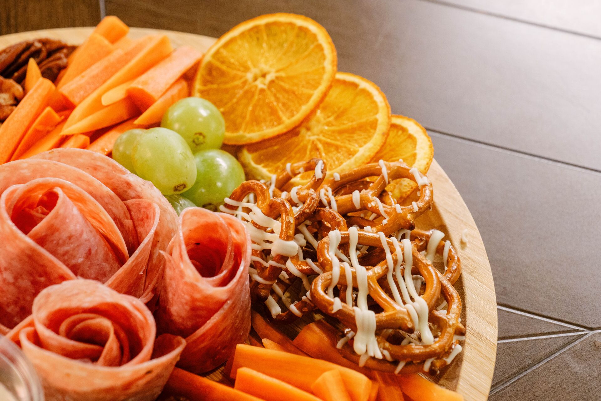 charcuterie plate with meats, pretzels, and fruit