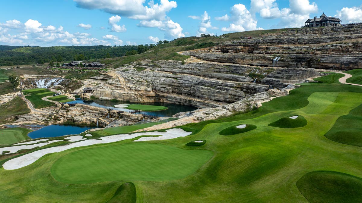 Uniquely shaped bunkers line a rolling hole that overlooks a pond at Cliffhangers golf course at Big Cedar Lodge