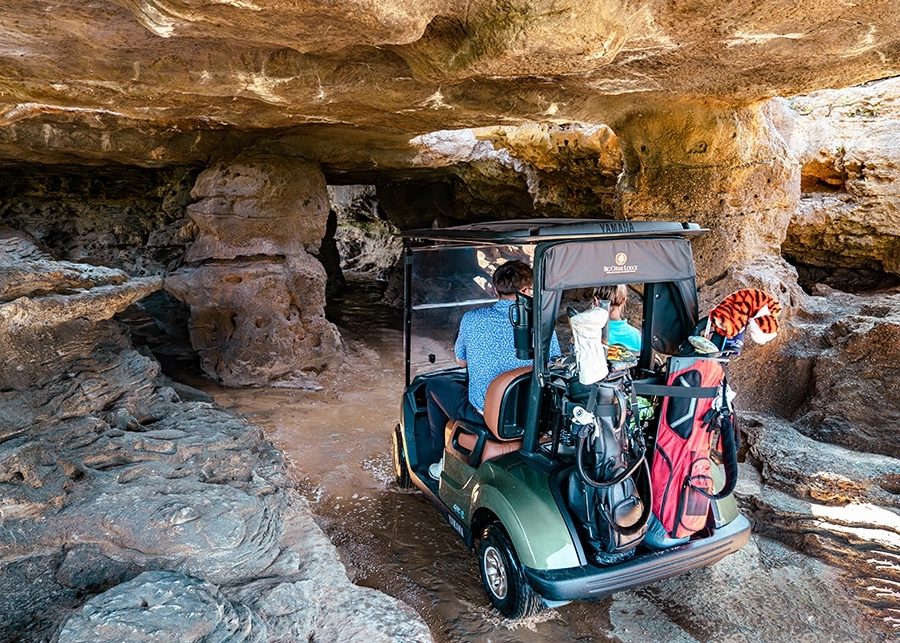 golf cart riding through a cave at cliffhangers golf course