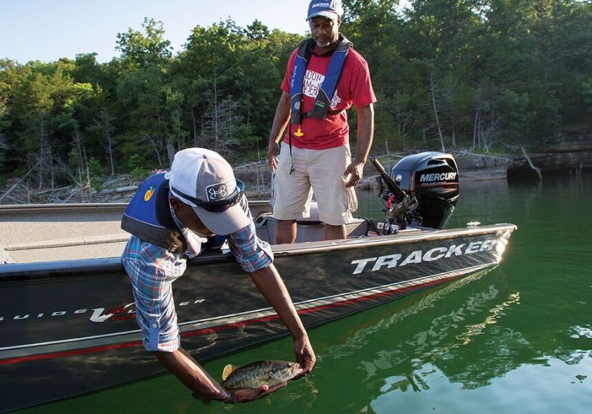 fisherman catching a fish off a tracker boat on table rock lake