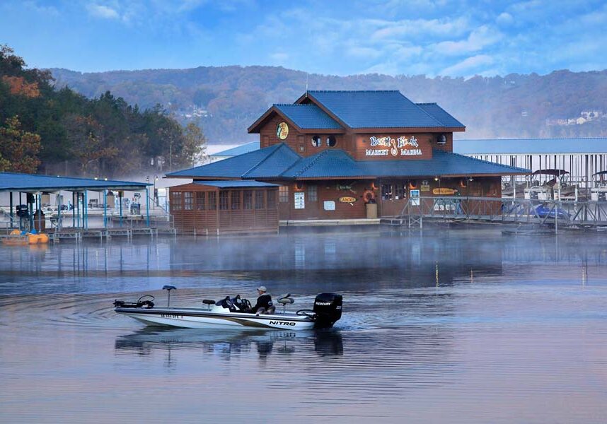 Fisherman out on his boat on an early foggy morning at Bent Hook Marina at Big Cedar