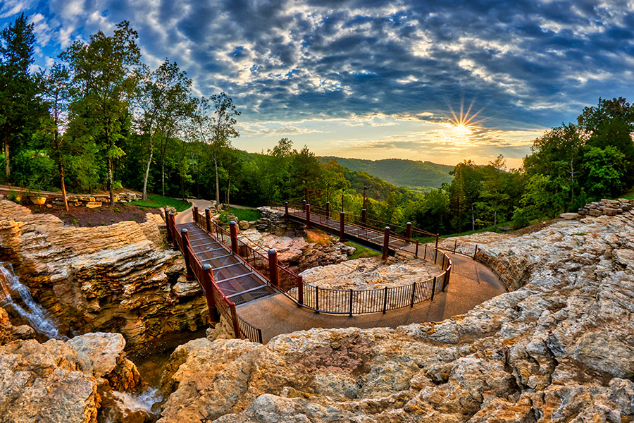 Cave trail carved out of the rock in the Ozark Mountains with vivid sky and sunset