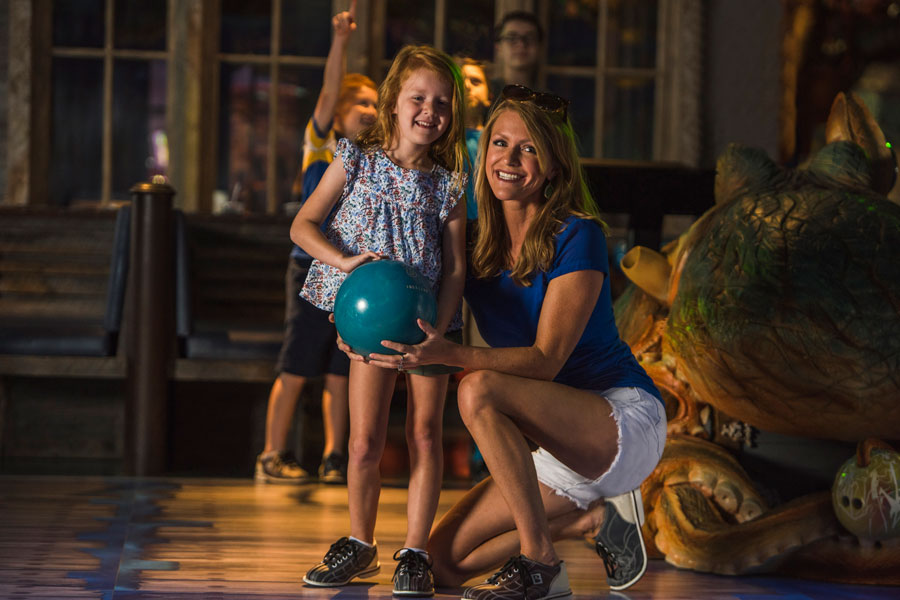 Mom helping daughter bowl at Fun Mountain underwater-themed bowling alley at Big Cedar