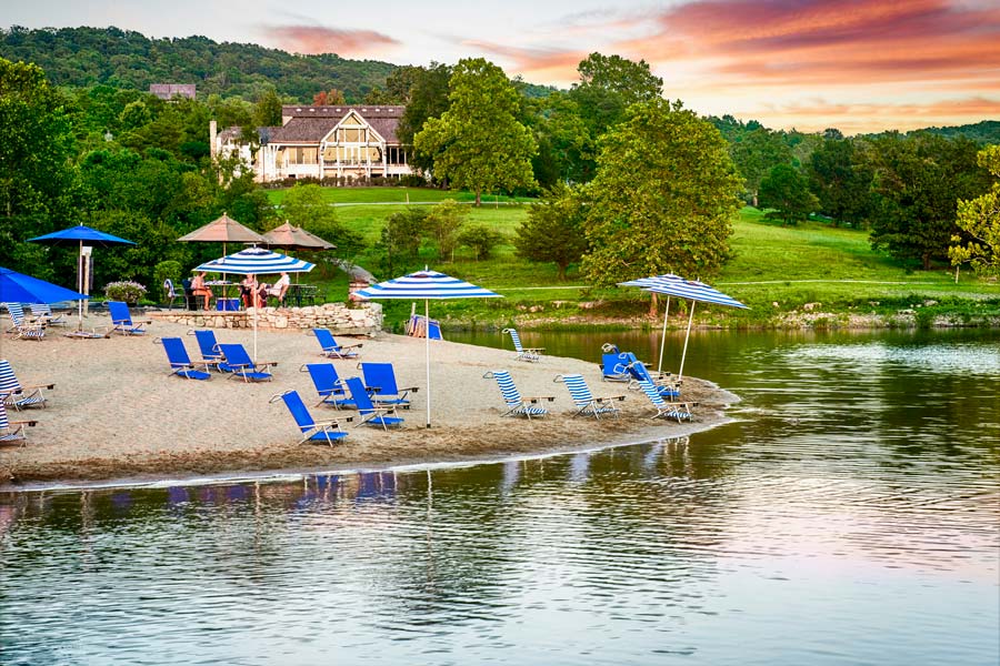 Beach chairs and umbrellas in the sand at Bent Hook Marina beach at Big Cedar