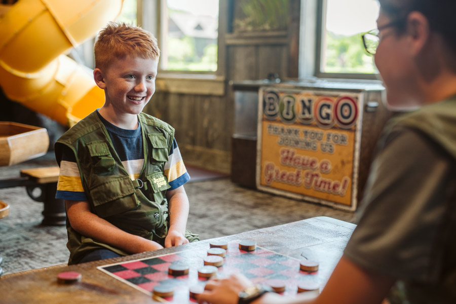 Kid playing checkers at the Discovery Center at Fun Mountain at Big Cedar