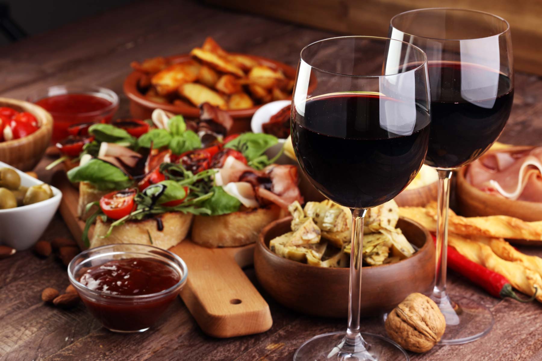 Two glasses of wine and food spread out on a table
