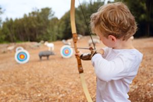 Boy shooting Bow and Arrow at targets