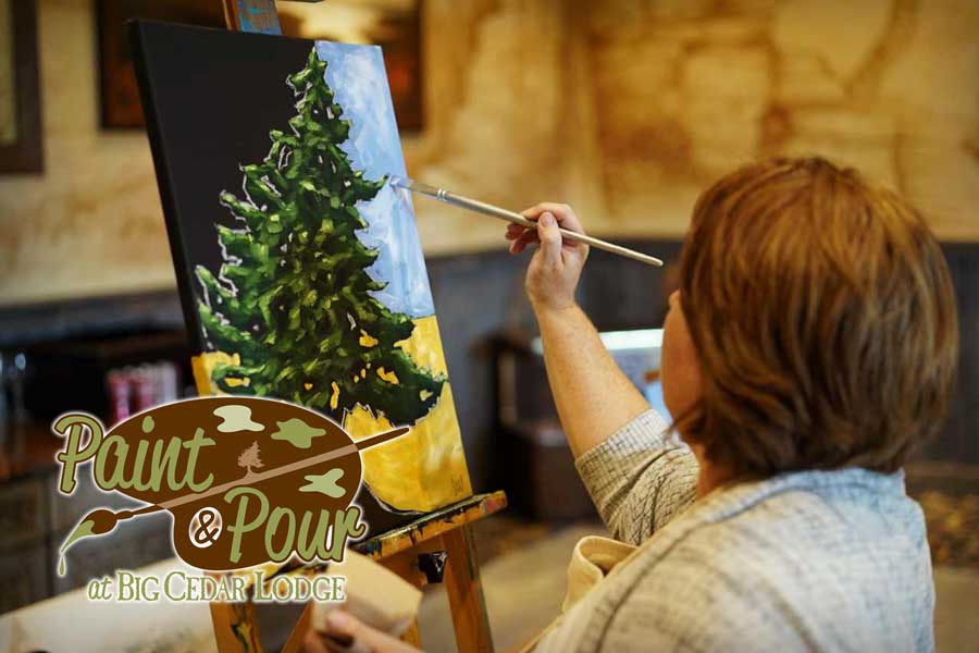 Woman painting a cedar tree at Big Cedar's Paint & Pour