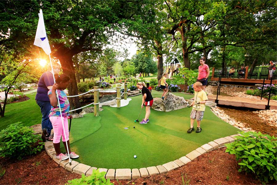 Adults and Children Participating in a Mini Golf Tournament