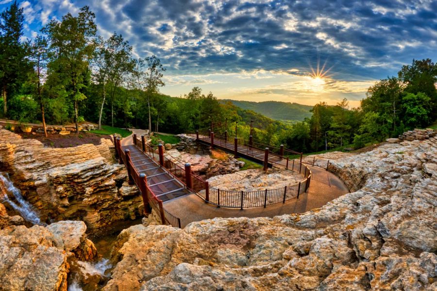 Cave trail carved out of the rock in the Ozark Mountains with vivid sky and sunset