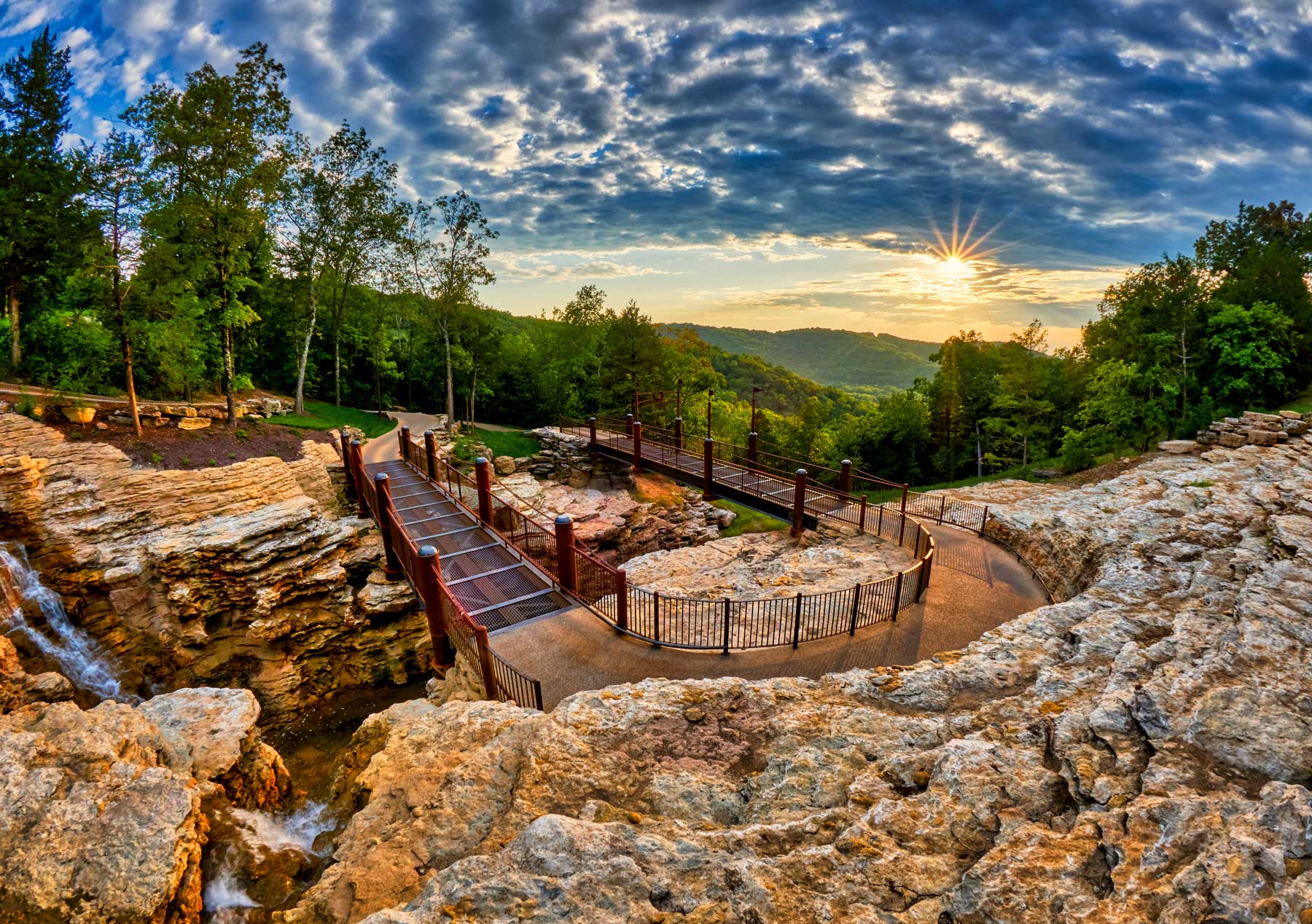 Cave trail carved out of the rock in the Ozark Mountains with vivid sky and sunset