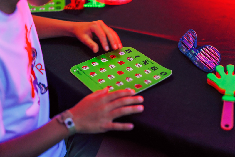 glowing bingo card and fluorescent objects lit by black light