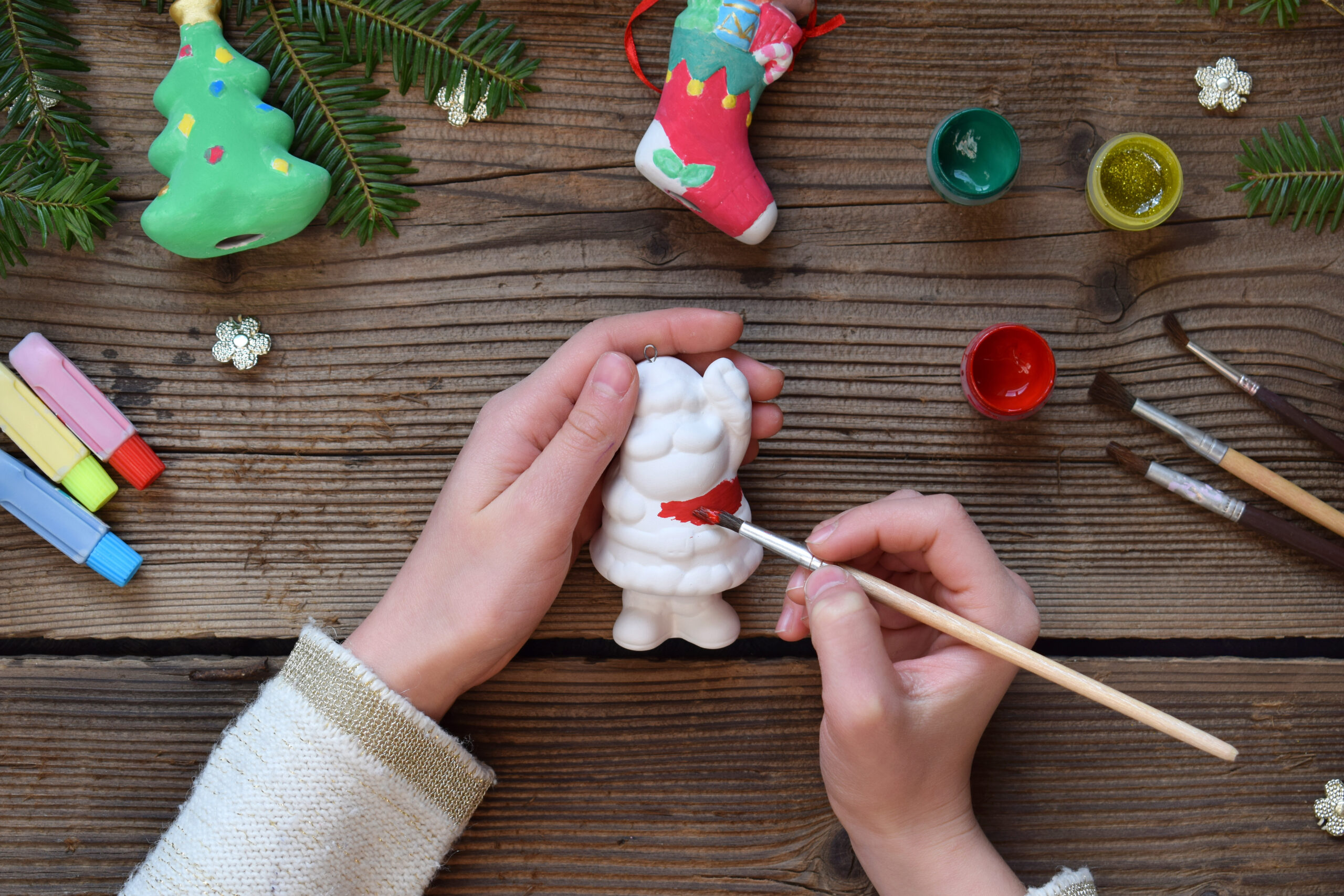 Painting Christmas toys from porcelain for decorations. Making clay toy with your own hands. Children's DIY concept. Handmade crafts on holiday. Master class of art.