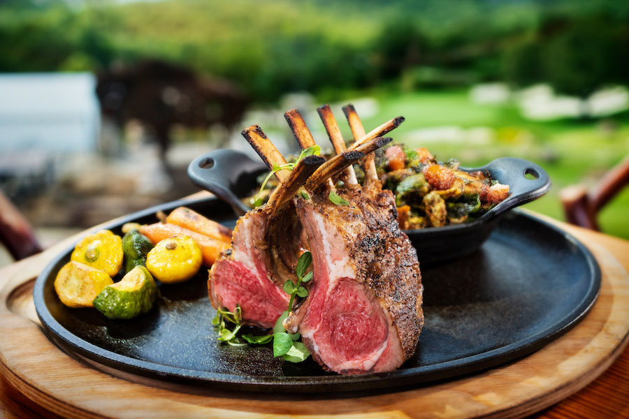 A plate of a rack of lamb and vegetables on the side, from the Osage Restaurant at Big Cedar Lodge.