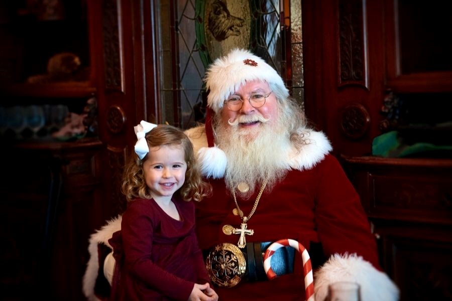 Santa and a little girl smile for a photo