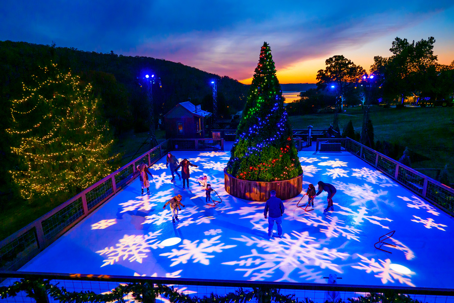 Christmas lights flicker around an ice skating rink