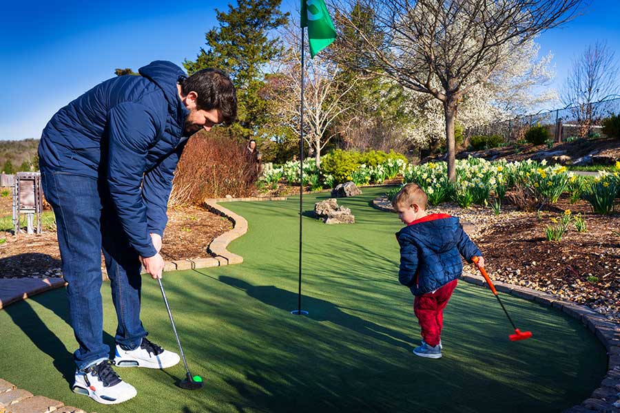 A father and young boy play mini golf at the Big Bass Mini golf course at Big Cedar Lodge