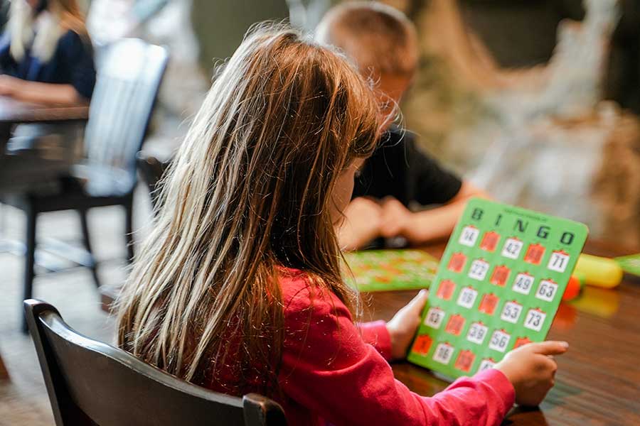 A little girl reviews her bingo board at Kids Bingo at Big Cedar