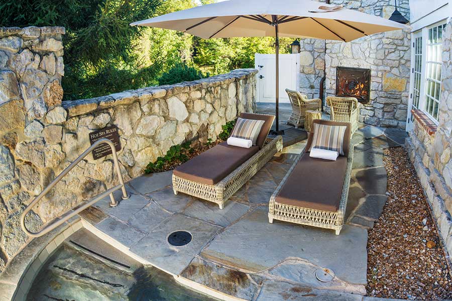 Two daybeds sit next to the entry stairs to a private outdoor Hot Spa at Cedar Creek Spa