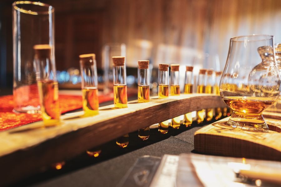 Test tubes of bourbon are lined up on a table for bourbon sampling.