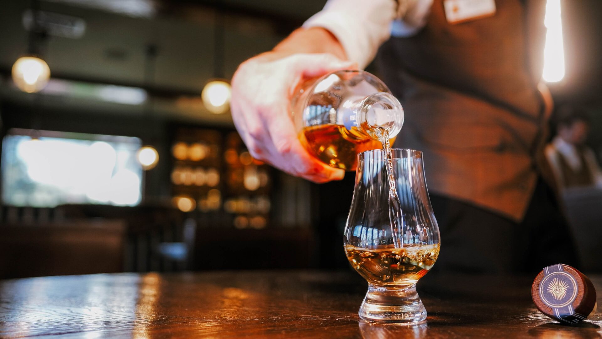 bartender pouring tequila into a glass