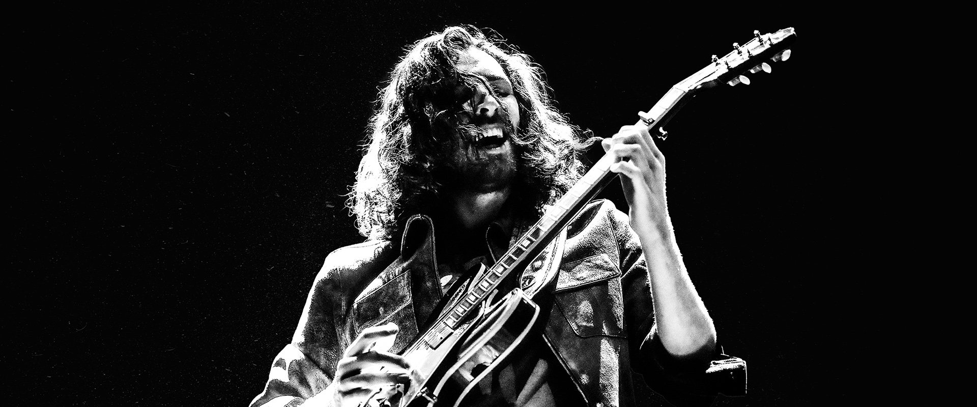 black and white photo of hozier playing guitar
