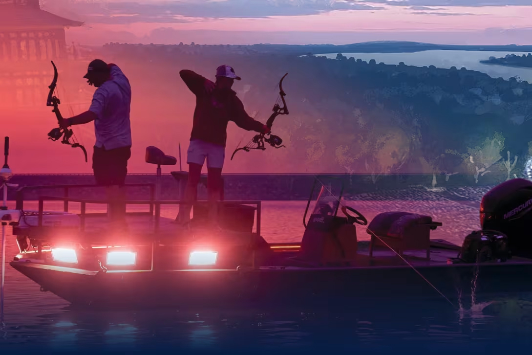 Two bowfishermen take aim while standing on a boat overlooking Table Rock Lake