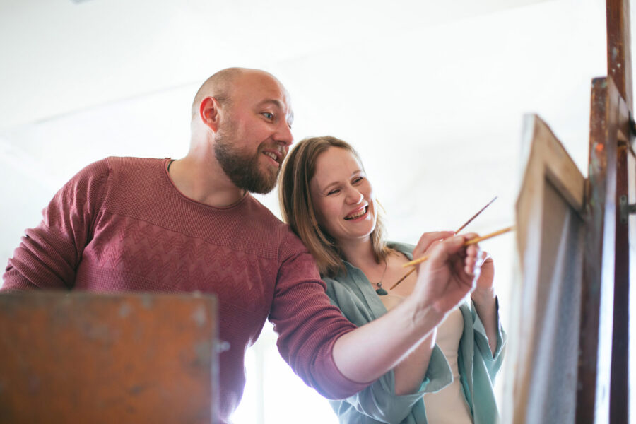 Painting lesson in the artist’s workshop. Loving couple have fun. Leisure hobby. Digital detox offline mental health positive emotions. Teacher student friends. Relaxing vacation drawing learn artwork