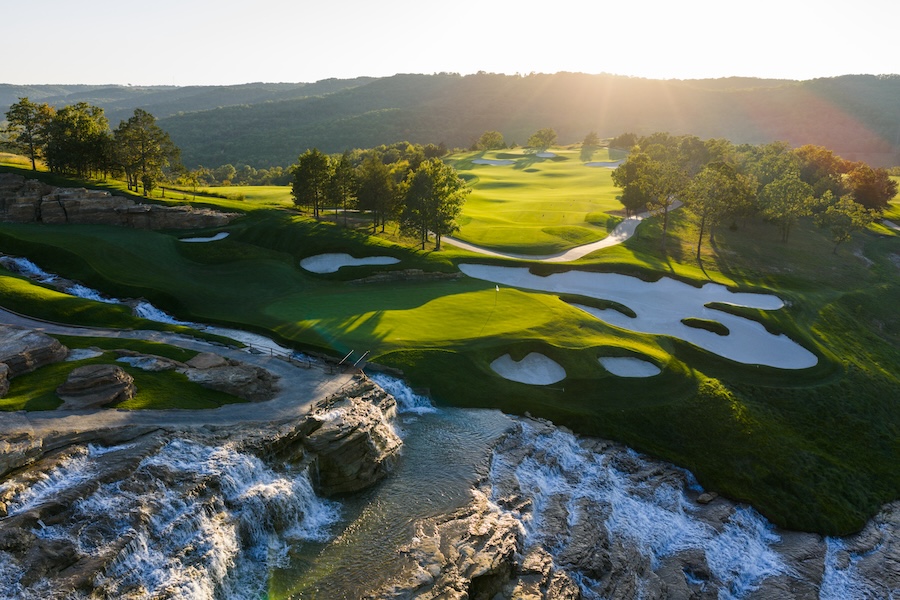 Golf course in the sun with challenging sand bunkers and beautiful water falls
