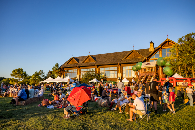 Outdoor picnic with large inflatable slides and people sitting on lawn chairs in front of Grandview Conference Center