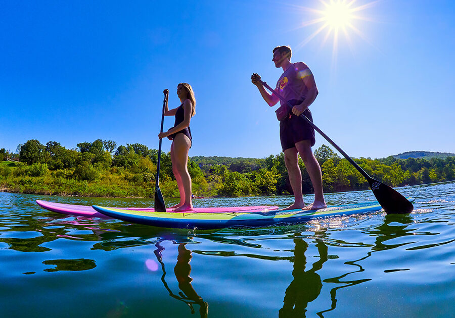 couple on lake with stand-up paddleboards
