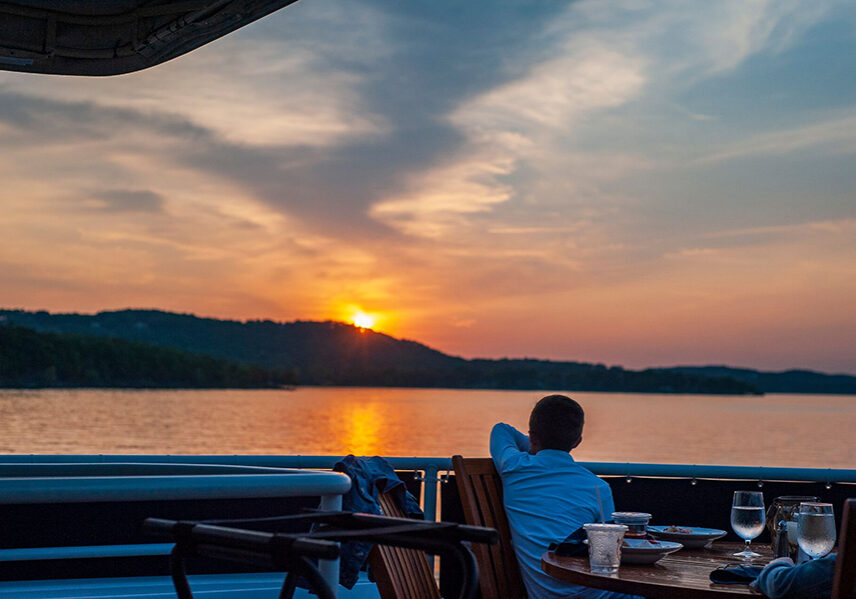 guest looks at the sunset across table rock lake during dinner cruise aboard lady liberty