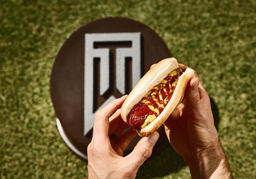 hot dog with mustard and ketchup in front of a tiger woods tee