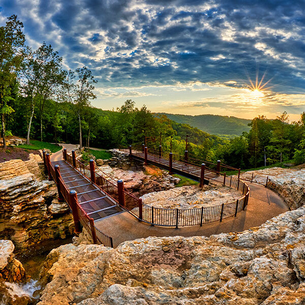 Cave trail carved out of the rock in the Ozark Mountains with vivid sky and sunset